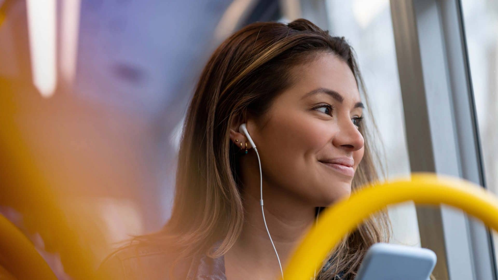 Girl on a bus with headphones and a phone