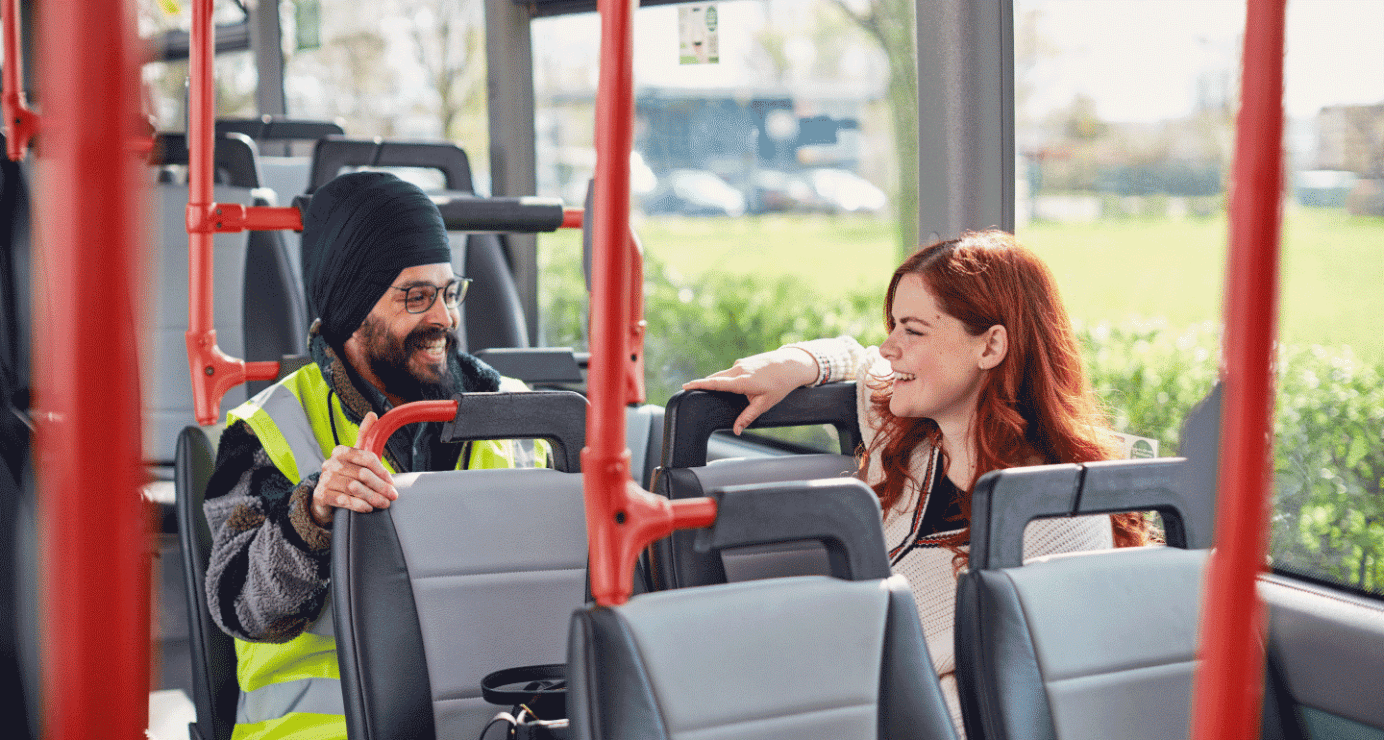 A man and a woman sitting on a bus talking