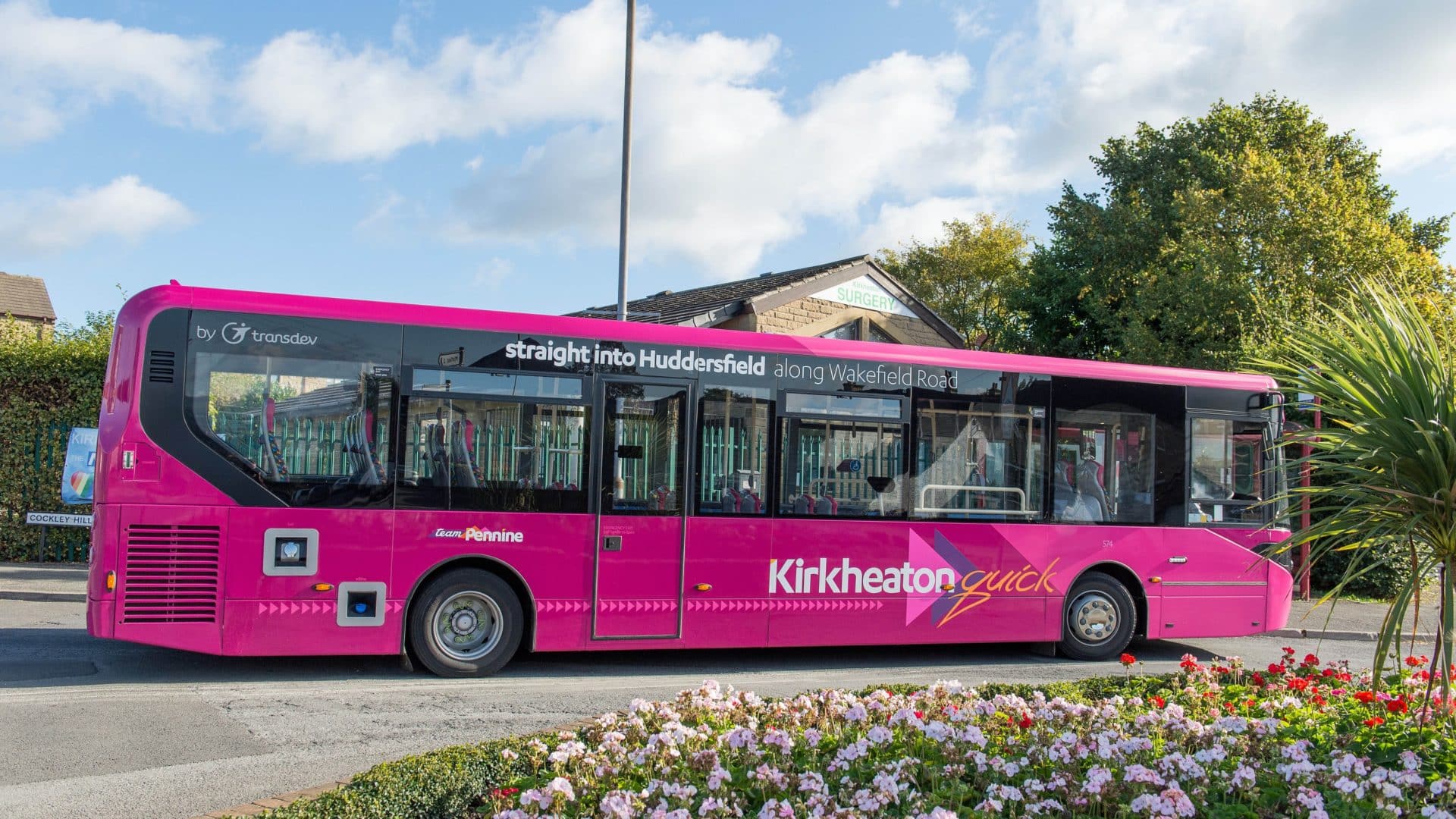 A bright pink Team Pennine bus