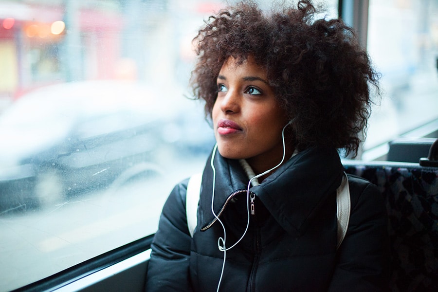 Young girl listening to music on a bus
