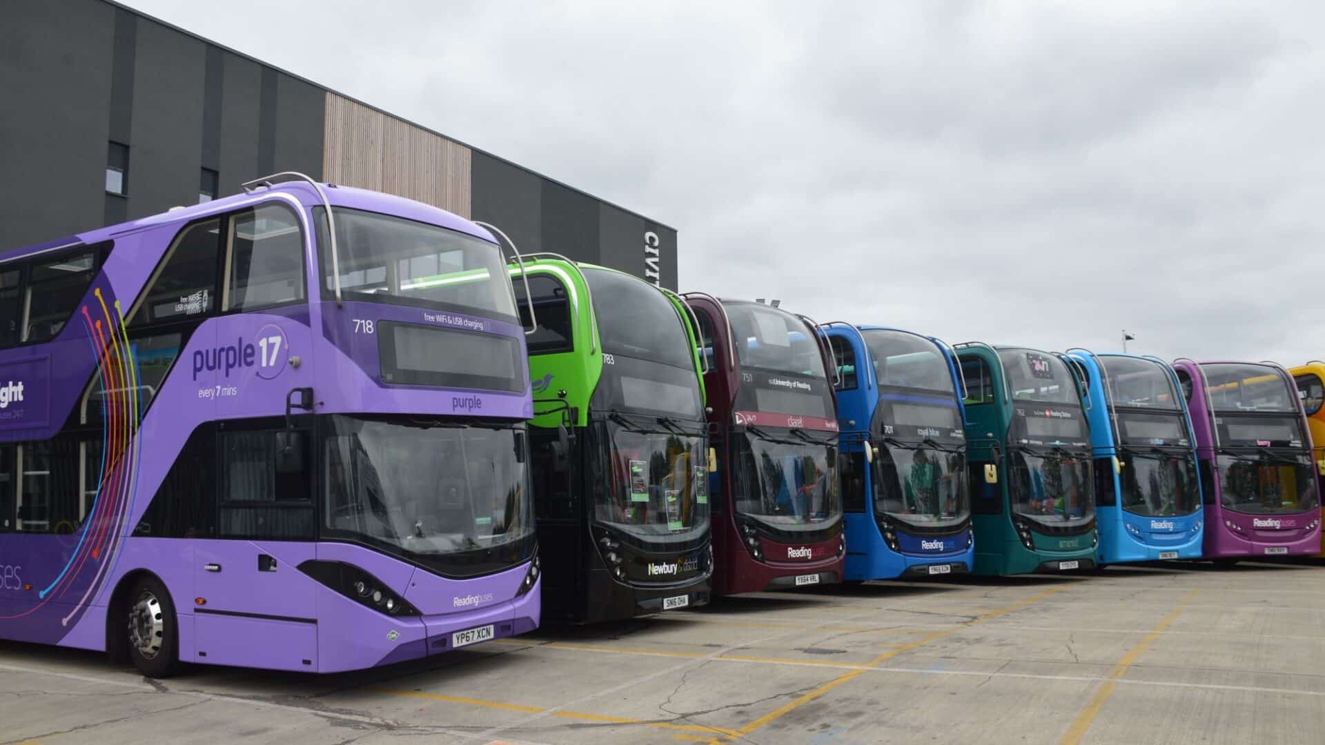 8 colourful Reading Buses double-decker buses lined up in the bus depot yard