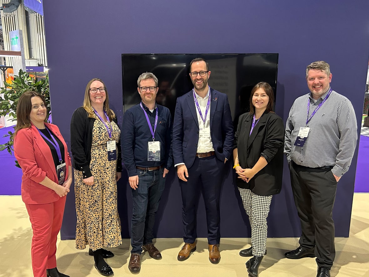 A group of people smiling for the camera on the Passenger stand at Euro Bus Expo 2024